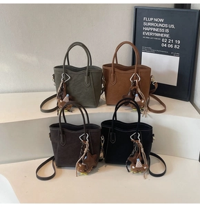 Detail von vier matten Wildledertaschen in Oliv, Karamell, Dunkelbraun und Schwarz
