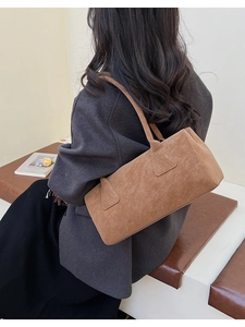 Détails d'un sac à épaule marron en daim au design minimaliste et anse fine élégante