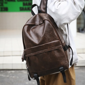 Close-up of vintage dark brown PU leather backpack with textured surface and front zipper pocket