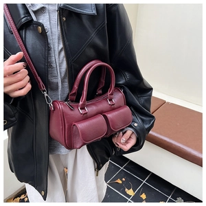 Burgundy faux leather barrel bag styled with double handles and front flap pockets