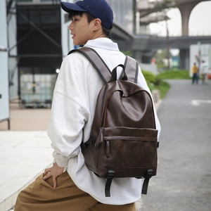 Close-up of the vintage brown leather backpack's textured surface and stylish zipper tassel