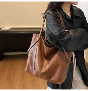 Vista dettagliata della borsa tote marrone in pelle PU con trama fine e manici lunghi