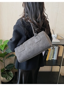 Sac cabas rectangulaire gris foncé en similicuir texturé porté à l'épaule par le mannequin