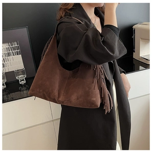 Close-up of a vintage dark brown matte shoulder bag with stylish fringe detail and hobo design
