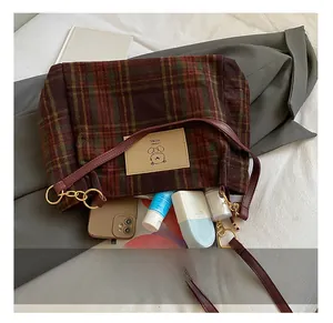 Detail view of plaid tote bag interior showing large capacity for phone and cosmetics
