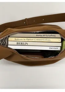 Interior view of brown faux leather bag showing large capacity with books and striped lining
