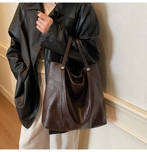 Modella che indossa una borsa tote oversize marrone scuro opaca per il look quotidiano