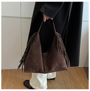 Detail of dark brown suede hobo bag with long bohemian tassels and spacious design