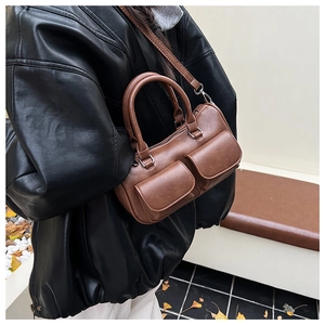 Brown vintage faux leather handbag with dual front pockets shown on a model outdoors