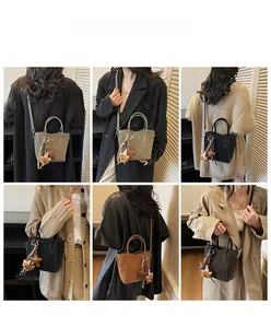 Détail de sacs fourre-tout en cuir de quatre couleurs avec texture lychee et breloques