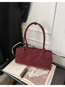 Détail du sac bandoulière bordeaux en daim synthétique avec texture mate minimaliste