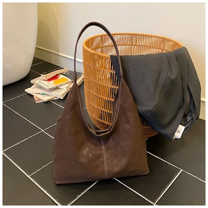 Detail of dark brown faux suede tote bag with distinctive white vertical stitching