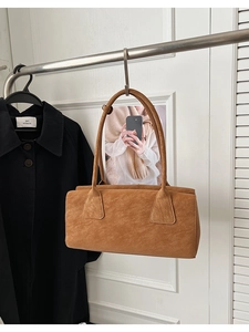 Gros plan détaillé d'un sac sous le bras en faux daim marron avec texture mate raffinée