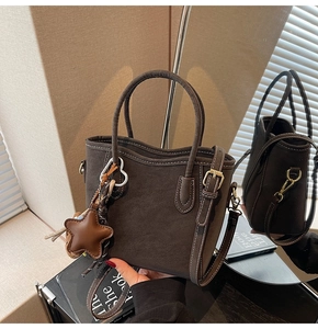 Détail du sac seau marron mat avec coutures blanches contrastées et pendentif étoile