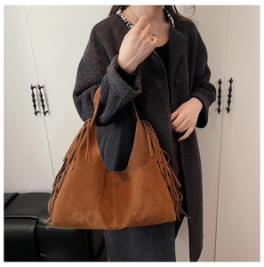 Close-up of the long fringe tassels and suede texture on a brown hobo shoulder bag