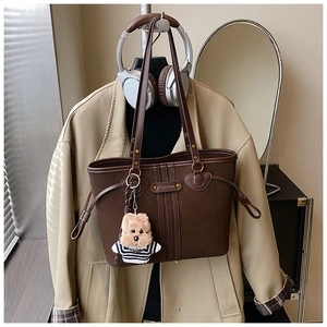 Détail d'un grand sac cabas marron café avec textures verticales et charme d'ours peluche