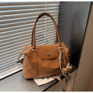 Detail of vintage brown faux leather tote with ethnic strap and plush bear charm