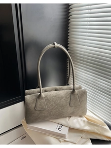 Détail d'un sac oreiller vintage gris avec texture vieillie sur soie blanche