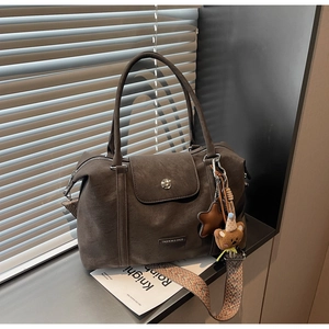Detail of vintage matte tote bag with ethnic strap, star charm and bear plush pendant