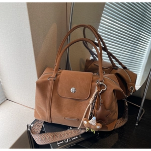 Detail of brown vintage boston bag with matte finish and ethnic style wide strap