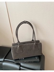 Gros plan d'un sac bandoulière gris foncé minimaliste avec double compartiment et fini mat