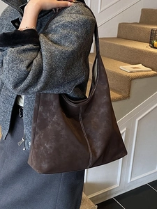Deep brown oversized tote bag in faux suede with contrast stitching on lifestyle model