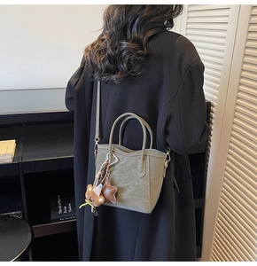 Détail du sac seau givré vert sauge avec pendentif ours et bandoulière réglable pratique