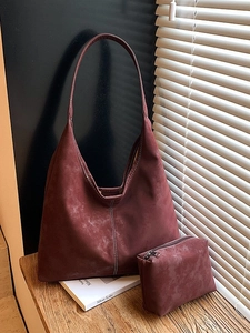 Vintage burgundy suede tote bag set with contrast stitching on wooden surface