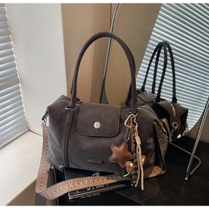 Detail of dark brown matte tote bag with ethnic woven strap and star pendant