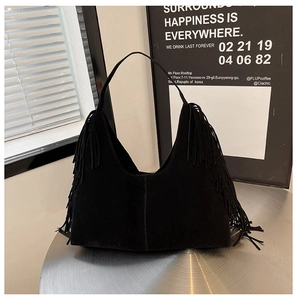 Detailed view of black matte suede texture and stylish long tassels on a hobo bag
