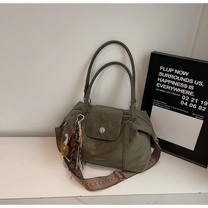Detail of olive green pillow bag showing vintage leather texture and woven shoulder strap