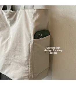 Detailed view of the side pocket on this large tote bag showing a smartphone stored inside