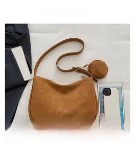 Detailed macro view of the brown suede hobo bag with a matching round coin purse and gold logo