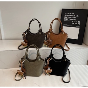 Detail of four matte textured bucket bags with unique knotted handles and bear charms