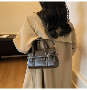 Dettaglio della borsa Boston vintage marrone scuro con cuciture bianche e texture in pelle