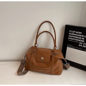 Brown Boston bag detail showing textured leather and ethnic jacquard woven shoulder strap