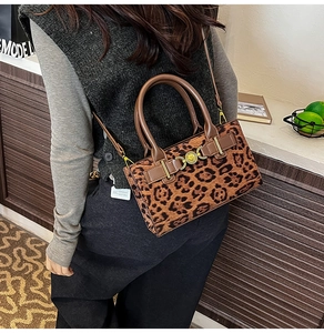 Close-up of leopard print crossbody bag with gold buckle and faux pony hair texture