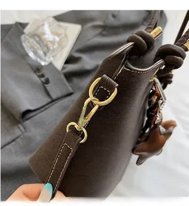 Detail of premium brown textured leather bucket bag with gold hardware and star charm