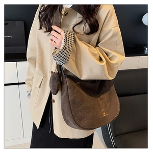 Detail of a brown matte Hobo bag with a mini circular coin purse and gold logo