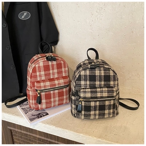 Detail view of plaid wool backpacks with metal zipper and leather shoulder straps