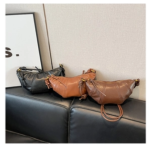 Three croissant shoulder bags in black, orange-brown, and dark coffee with knot detail