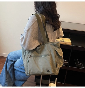 Detail of army green large canvas tote bag featuring functional side pockets and wide straps