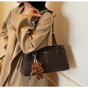 Deep brown suede tote bag with white contrast stitching and a cute bear charm pendant