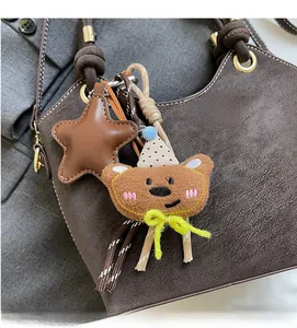 Detailed close-up of a cute brown bear charm with leather star on a luxury handbag