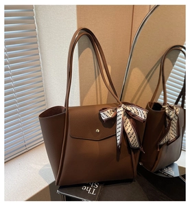 Détail d'un sac cabas marron avec foulard en soie et poche avant pratique