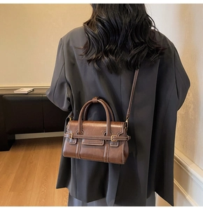 Dettaglio macro della borsa vintage marrone con fibbia in metallo e cuciture di qualità