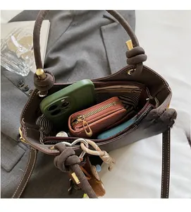 Top view of spacious brown tote bag interior with striped lining and daily essentials