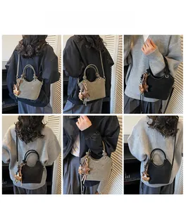 Detail view of stylish women's bucket bag showing versatile strap and bear charm