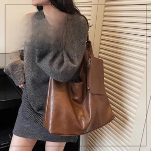 Close-up of brown leather tote bag with matching coin purse and adjustable shoulder strap
