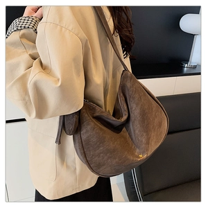 Detail of matte coffee brown hobo bag showing minimalist texture and golden logo